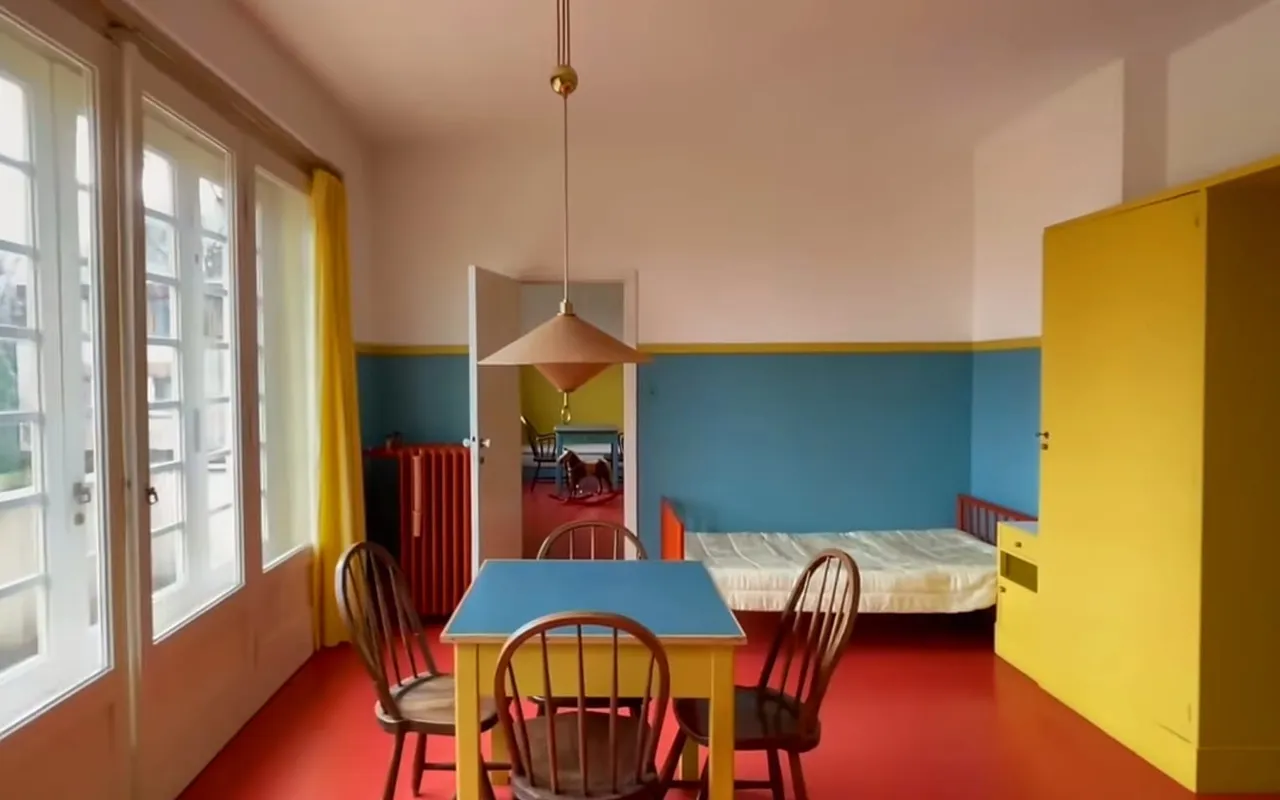 The children's room in Villa Müller with a red floor, blue walls and a yellow wardrobe