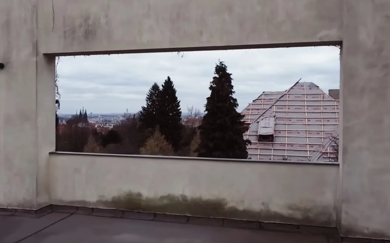 The roof terrace of Villa Müller: a large opening in the terrace wall frames trees and the city skyline